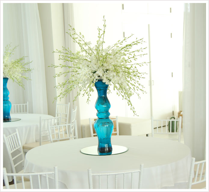 They were white dendrobium orchids in tall sea blue glass vases which I 39m